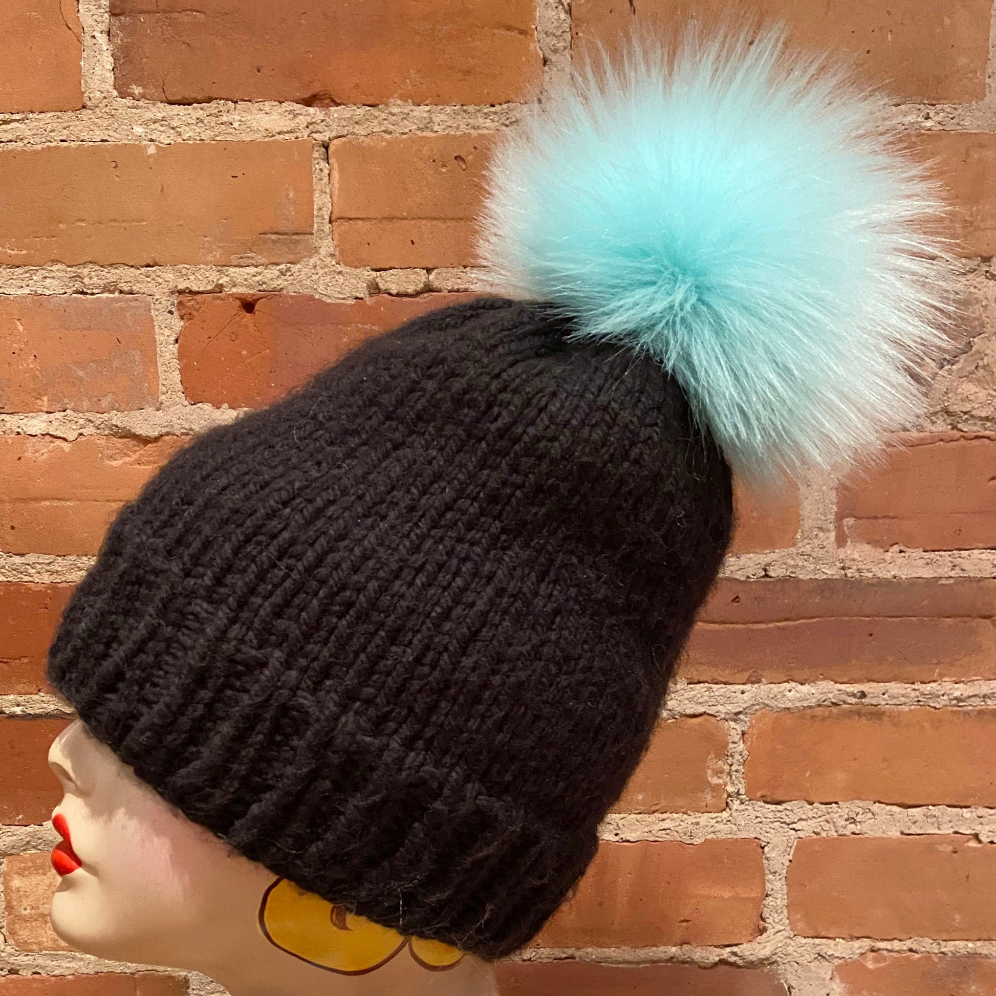 Side View of Aqua Pom Attached to a Knit Hat