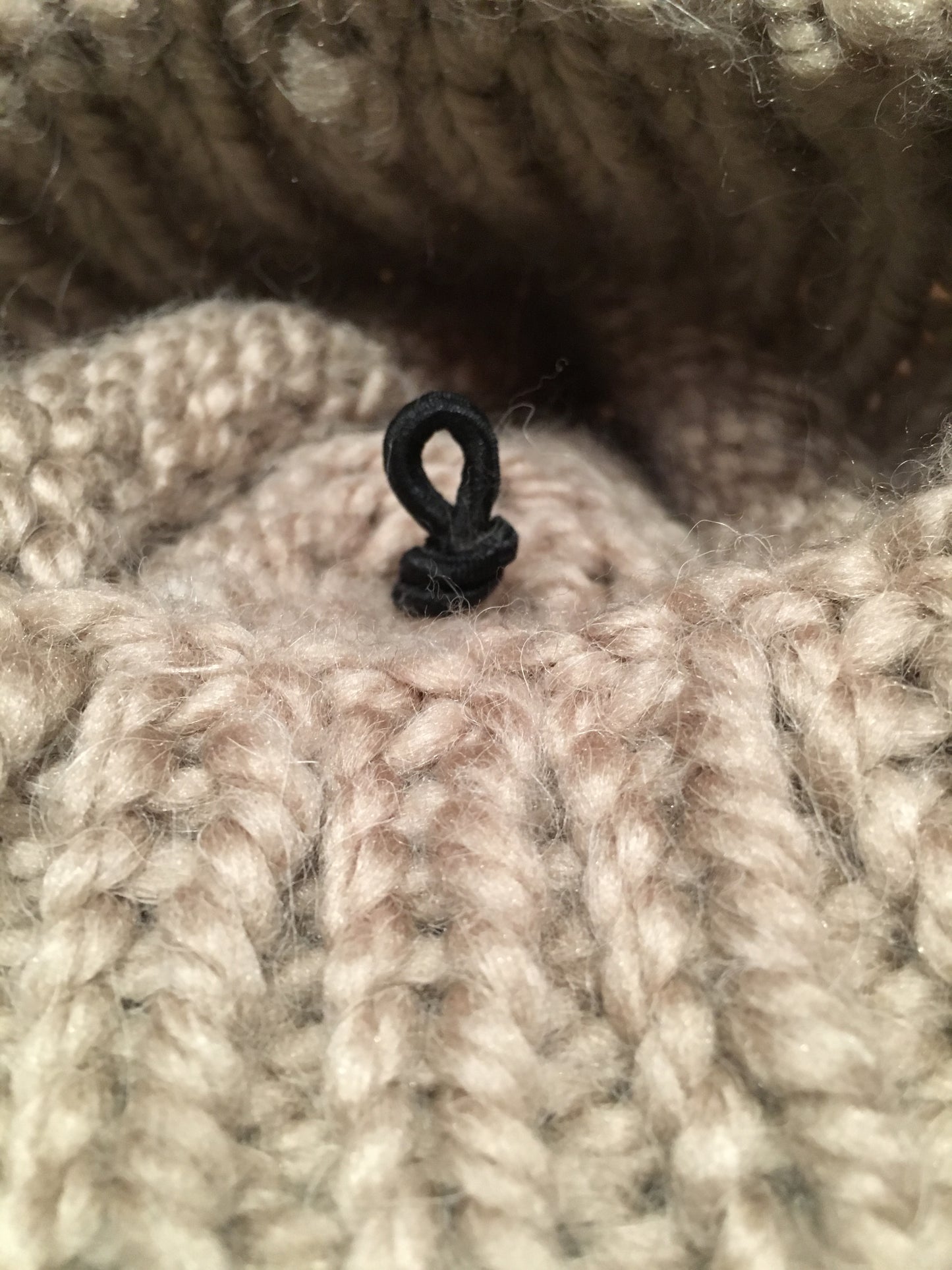 Hat Pom Pom Elastic Loop Attachment Knot Shown on the Inside of Knit Hat