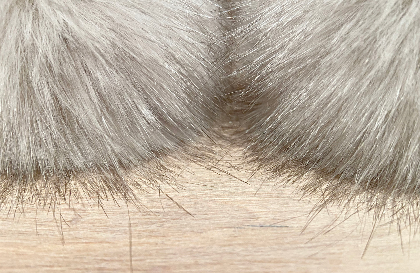 close up view of the fur of beige elle faux furs pom poms
