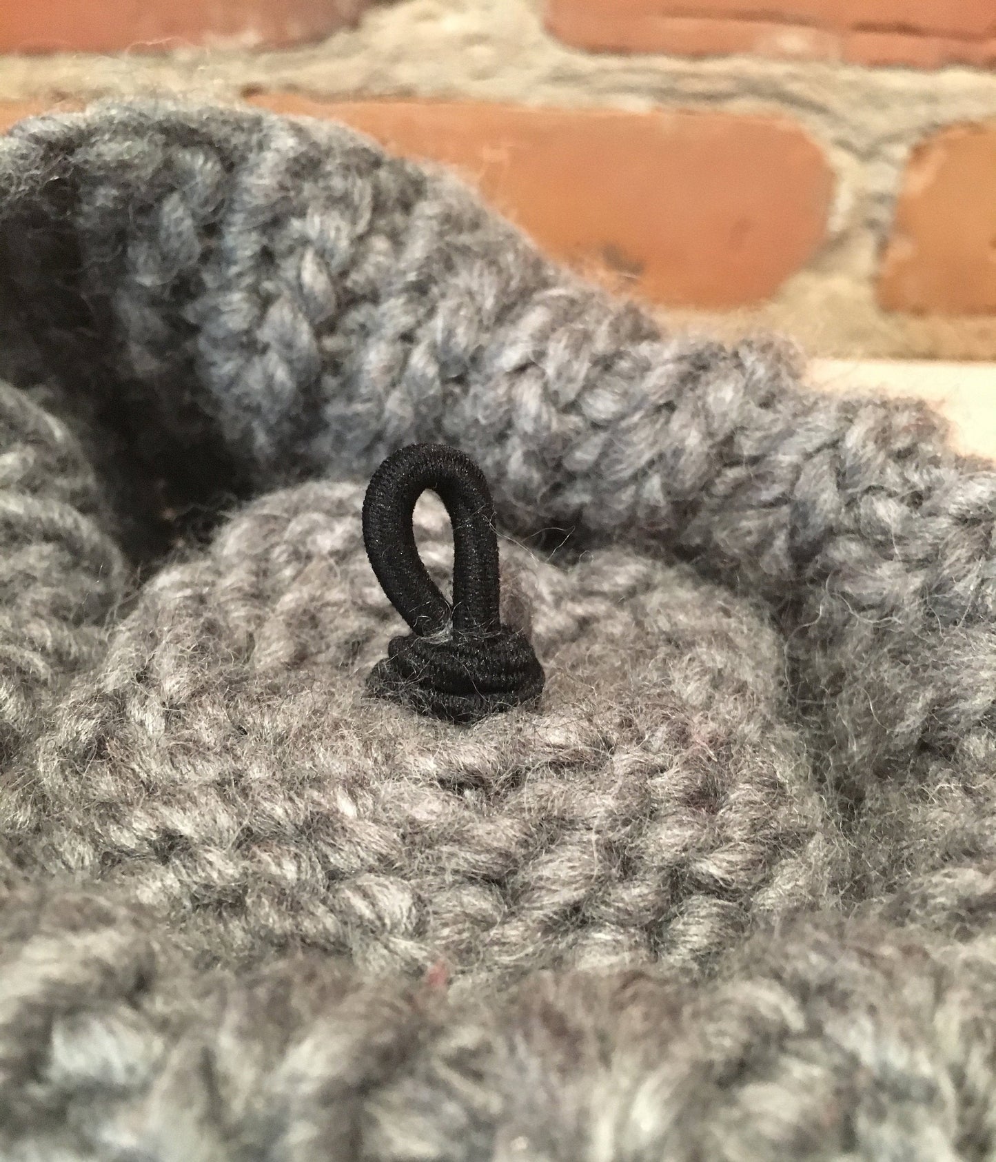 inside view of the hat pom loop attachment of knit hat
